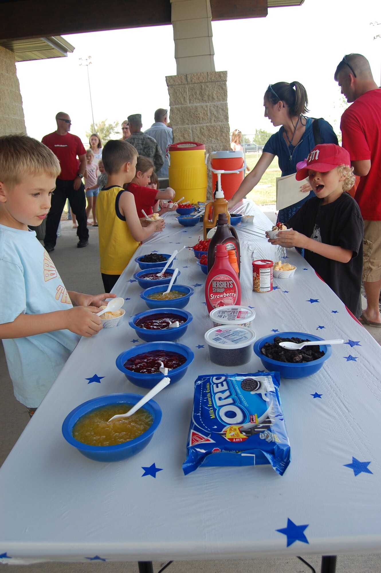 Little Warriors make ice cream sundaes after the Little League closing ceremony at field 7 June 23. The ceremony was held to recognize those who participated in Little League throughout the season. (U.S. Air Force photo/Airman 1st Class Emerald Ralston)