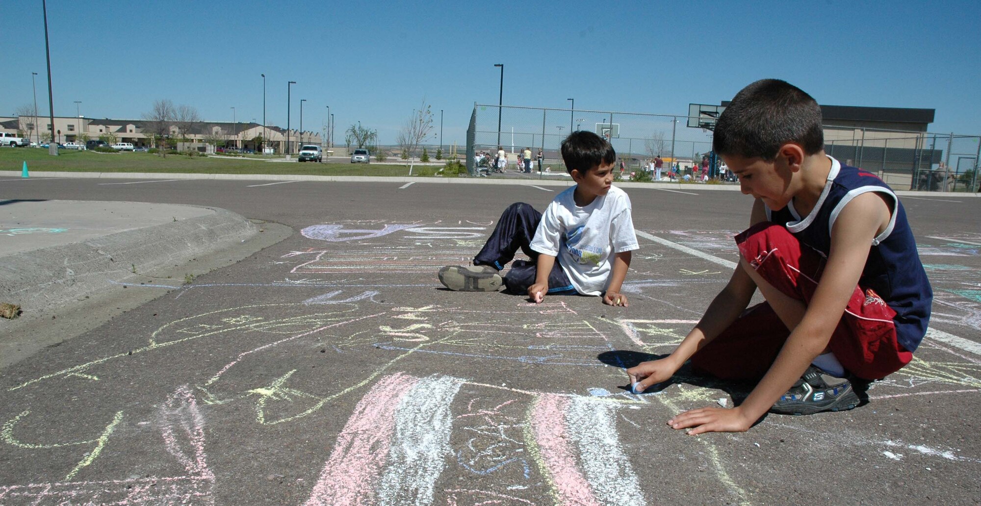 Little warriors Eli and Josh, 8, work on their USA-themed chalk artwork during the Youth Program Center's annual Chalk-it-Up! competition Wednesday. (U.S. Air Force photo / Airman 1st Class Dillon White) 