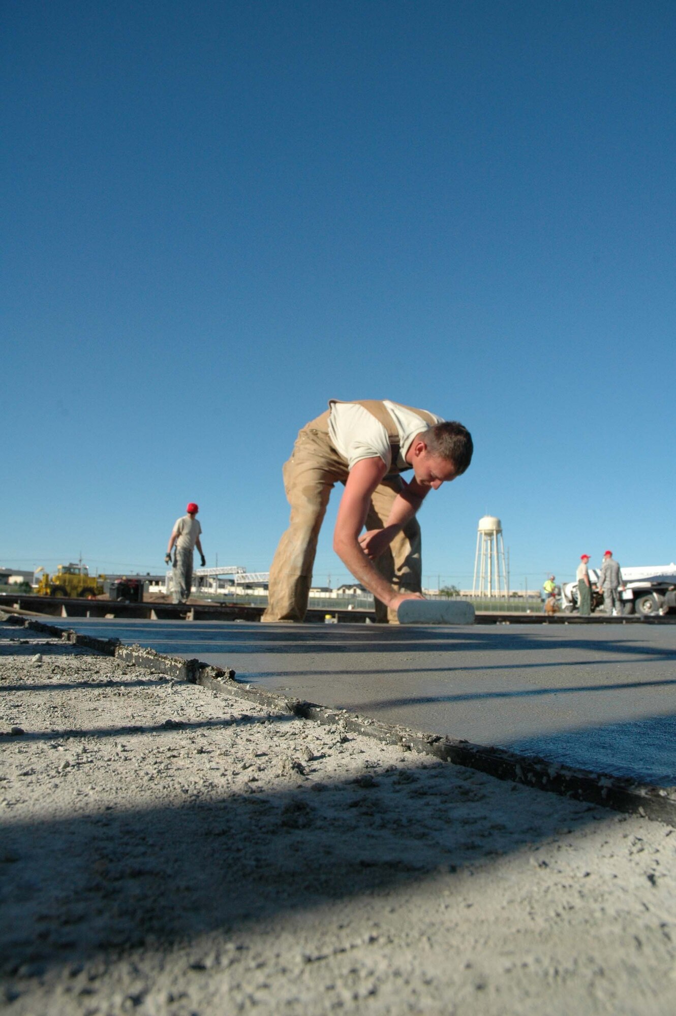 Senior Airman Matt Sywassink, 819th RED HORSE Squadron member, smooths concrete at the base heat plant June 19. (U.S. Air Force photo/ Airman 1st Class Dillon White)