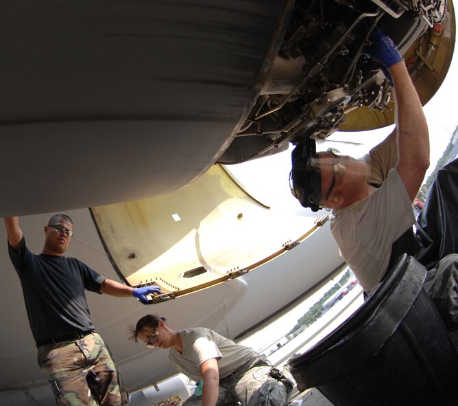 SEYMOUR JOHNSON AIR FORCE BASE, N.C. - Senior Airman Martin Quintanilla, Tech. Sgt. Amy Eveslage and Staff Sgt. Timothy Anglin of the 916th Air Refueling Wing inspect and change a fuel filter on a KC-135R Stratotanker here June 23. Fuel filters on the KC-135R must be serviced every 120 flying hours. (U.S. Air Force photo by Airman 1st Class Gino Reyes) 