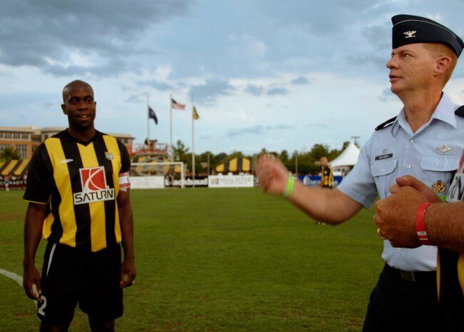 Col. John "Red" Millander flips the coin to determine which team would have possession of the ball to begin the soccer match between the Charleston Battery and the Minnesota Thunder at Blackbaud Stadium in Charleston, S.C., June 20. The Charleston Battery team provided free tickets for Airmen and family members as part of their military appreciation night. Colonel Millander is the 437th Airlift Wing commander and was invited to the game in honor of military appreciation night. (U.S. Air Force photo/Airman 1st Class Katie Gieratz)