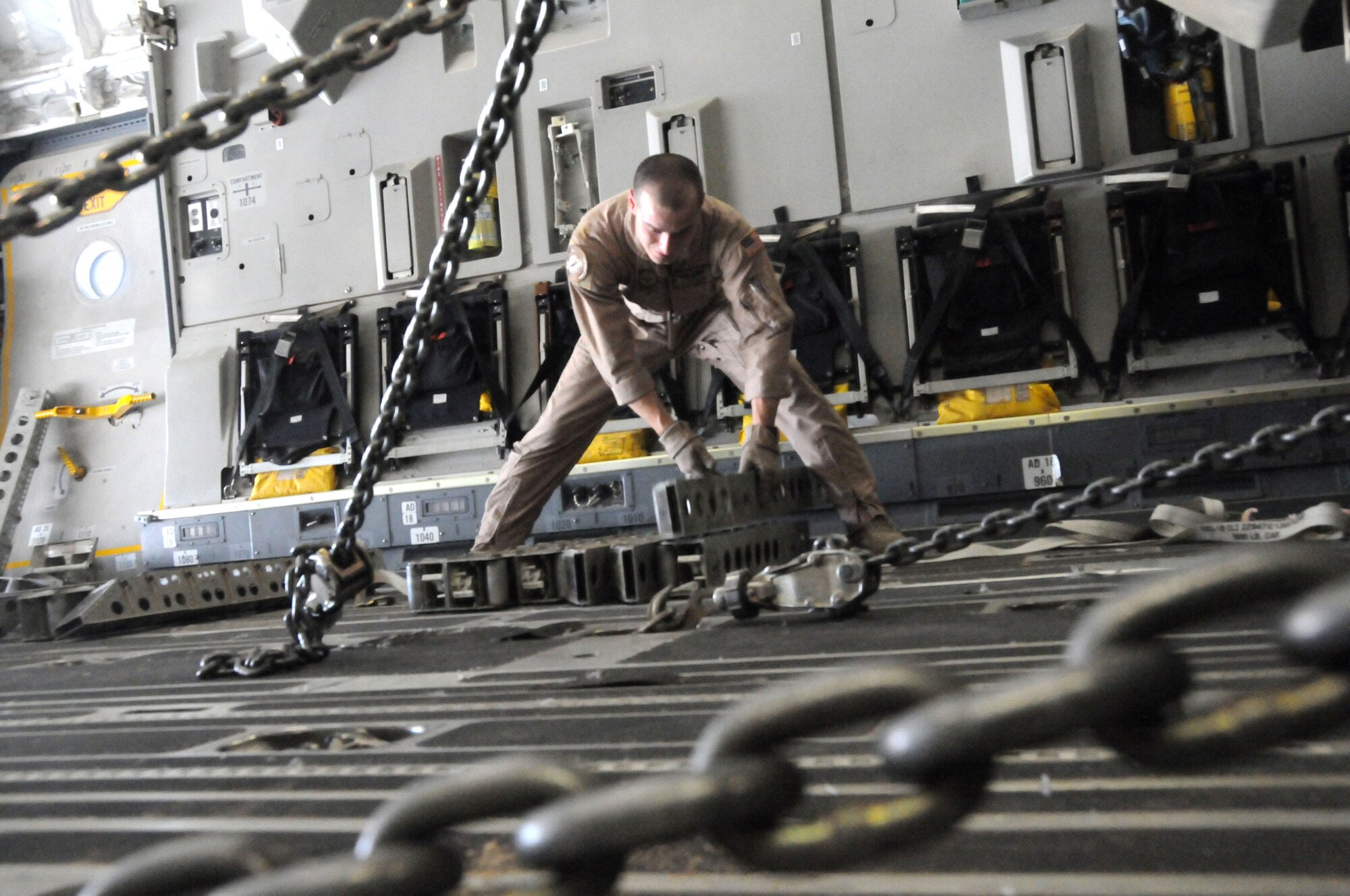 SOUTHWEST ASIA-Staff Sgt. Jason Harmon, 816th Expeditionary Airlift Squadron loadmaster stack rollers prior to securing it to the C-17s deck, at Bagram Air Base, Afghanistan June 19. Sergeant Harmond ensures that supplies being airlifted are distributed evenly in the cargo hull.(U.S. Air Force photo/ Senior Airman Tong Duong)