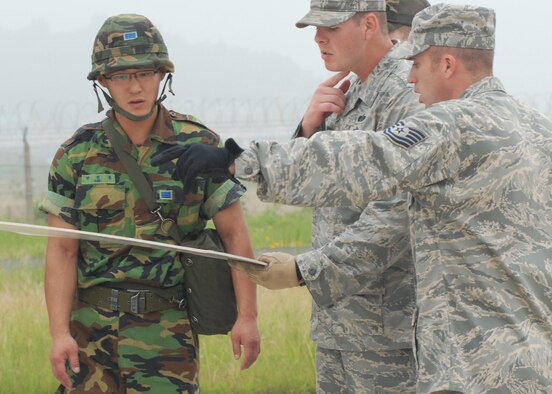 KUNSAN AIR BASE, Republic of Korea—Republic of Korea Army Corporal Chunyong Park from the First Battalion, Staff Sgt. Peter Rockey, NCO in charge of logistics and Tech. Sgt. Frank Roman, NCO in charge of readiness and training from the 8th Civil Engineer Squadron review the layout for the decontamination stations here June 24. (U.S. Air Force Photo/Staff Sgt Araceli Alarcon) 