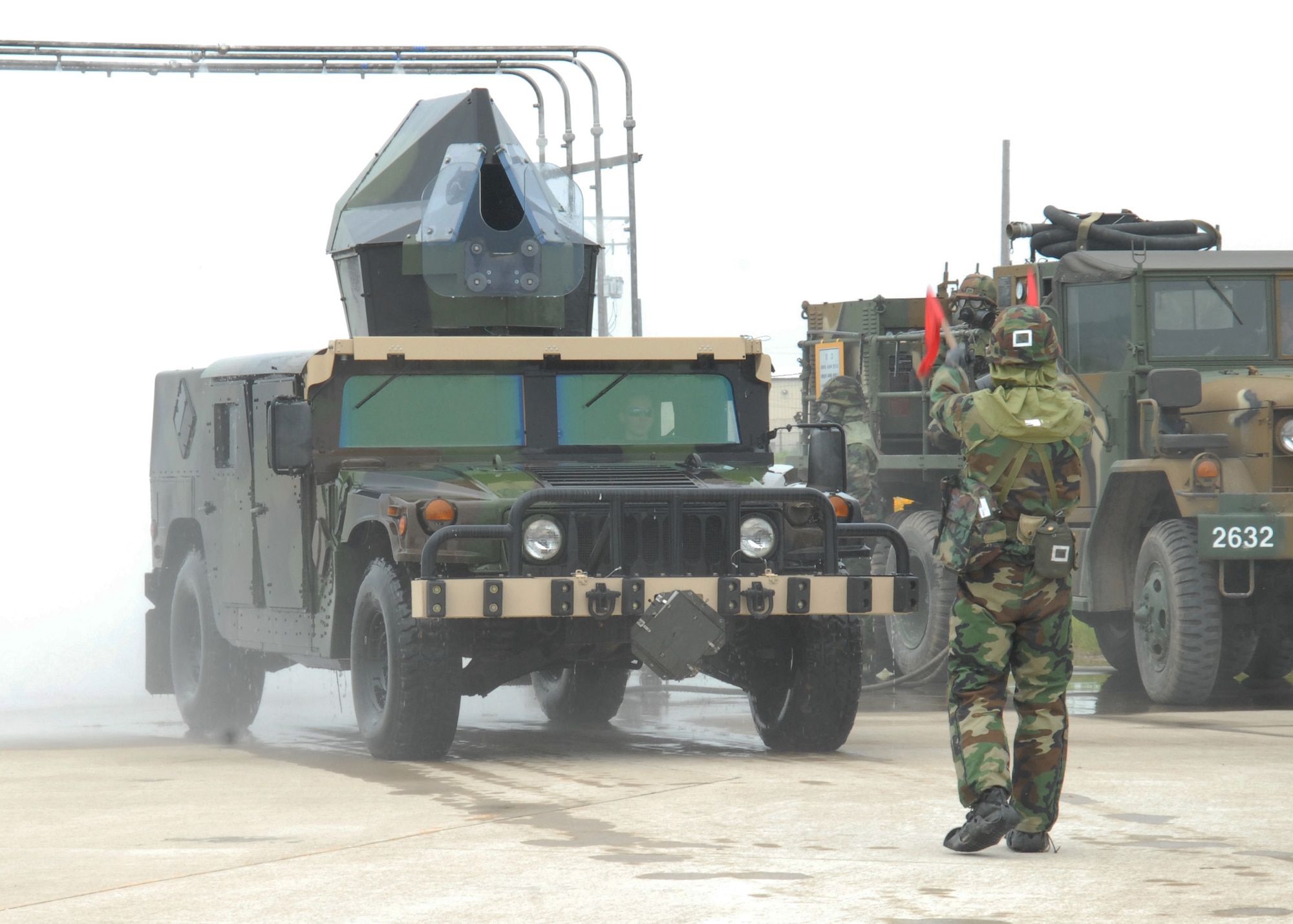 KUNSAN AIR BASE, Republic of Korea –A Republic of Korea Army soldier guides a high mobility multipurpose wheeled vehicle (HMMWV) from the 8th Civil Engineer squadron through a vehicle decontamination station here 24 June. (U.S. Air Force Photo/Staff Sgt Araceli Alarcon)