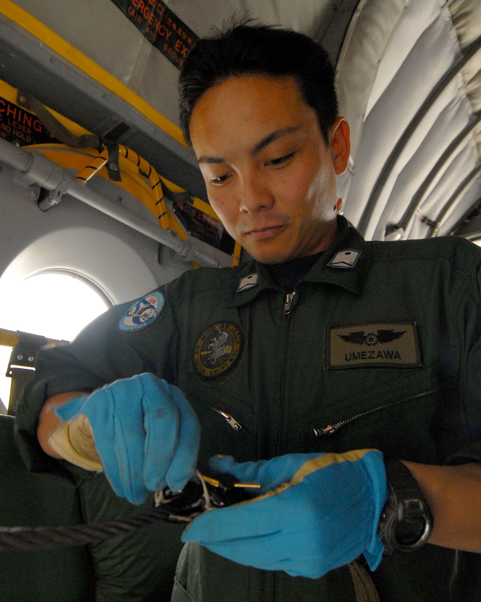 YOKOTA AIR BASE, Japan -- Japanese Air Self Defense Force's Staff Sergeant Satoshi Umezawa preps cargo, during a cargo prep demonstration at Miho Air Base, for visiting U.S. Air Force members during a bilateral airlift aircraft training on 23 June.(U.S. Air Force photo by SrA Laszlo Babocsi)