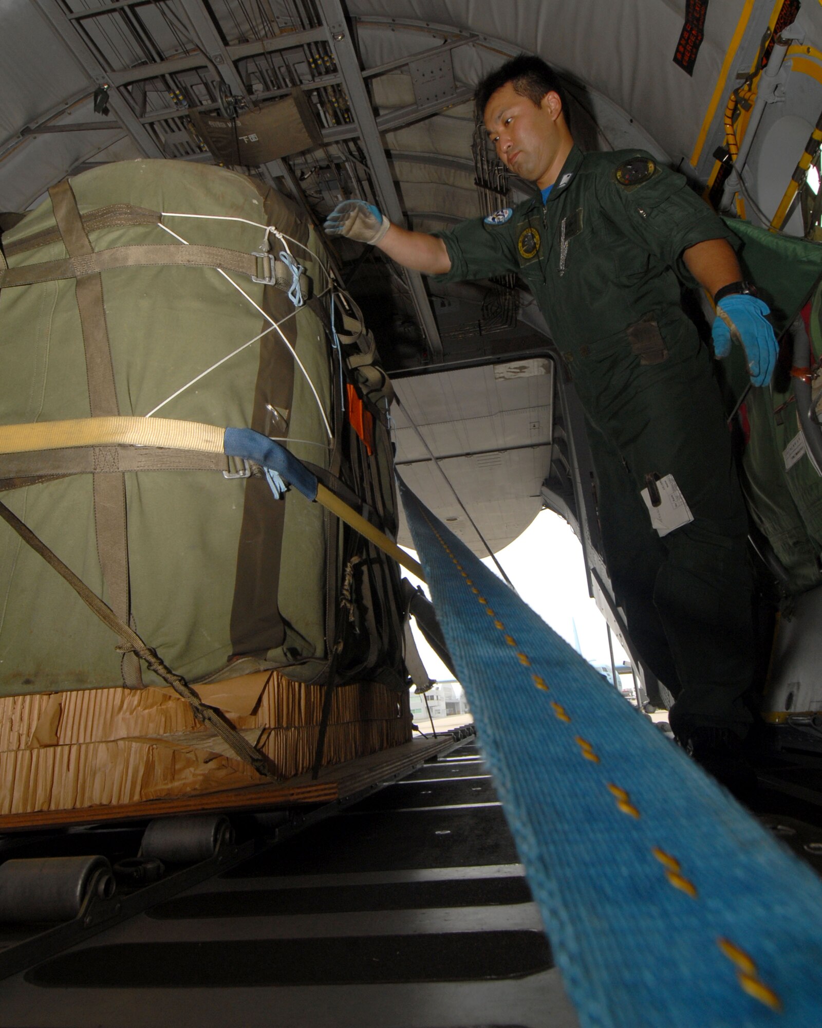 YOKOTA AIR BASE, Japan -- Japanese Air Self Defense Force's Staff Sergeant Takeda Takayuki inspects cargo during a cargo prep demonstration at Miho Air Base, for visiting U.S. Air Force members during a bilateral airlift aircraft training on 23 June.(U.S. Air Force photo by SrA Laszlo Babocsi)