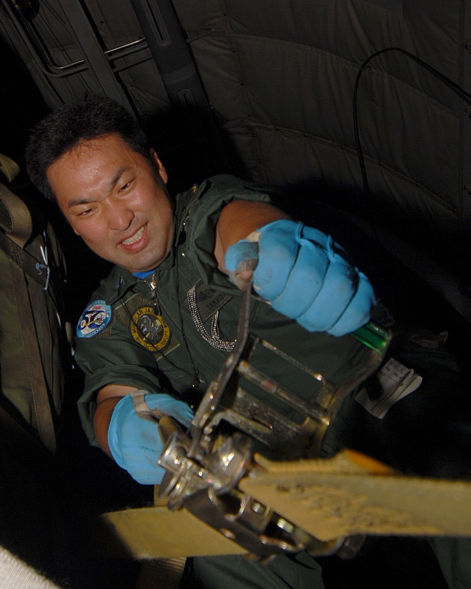 YOKOTA AIR BASE, Japan -- Japanese Air Self Defense Force's Staff Sergeant Takeda Takayuki tightens down cargo  during a cargo prep demonstration at Miho Air Base, for visiting U.S. Air Force members during a bilateral airlift aircraft training on 23 June.(U.S. Air Force photo by SrA Laszlo Babocsi)