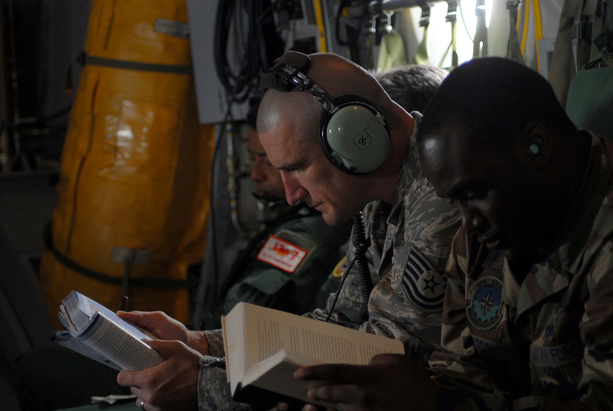 YOKOTA AIR BASE, Japan -- Technical Sergeant Jeremiah Sutton and Staff Sergeant Chad Gordon from the 374th Maintenance Squadron take in some reading, while on their flight to Miho Air Base, on 23 June. (U.S. Air Force photo by Senior Airman Laszlo Babocsi)