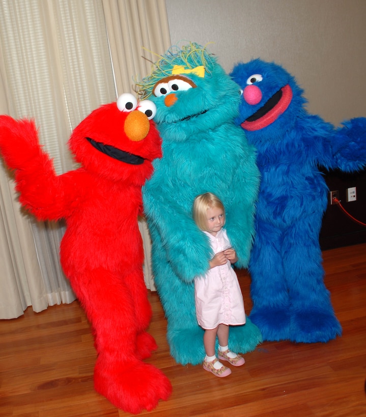 Lizzie Israel, 3, poses with Sesame Street characters Elmo, Rosita and Grover after they gave a sneak preview of their part of "The Sesame Street Experience," on June, 26, 2008. The launch of the live production designed to help military children cope with parents' deployments. The 60-minute program featuring Sesame Street characters will be presented on 43 military installations around the country by the end of the year. Lizzie's mom, Erin Streeter, works for the Department of Homeland Security. Defense Dept. photo by Samantha L. Quigley