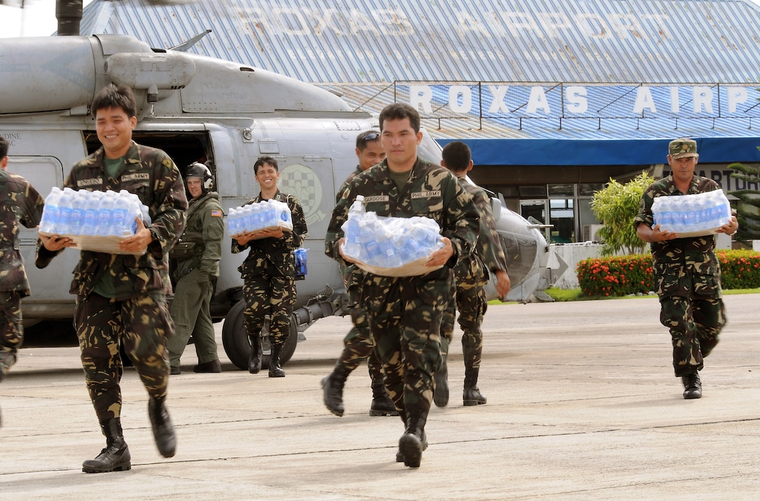 Philippine soldiers transport bottled water from a U.S. Navy SH-60 helicopter at Roxas Airport in the Philippines, June 26, 2008. The water will be distributed to people reeling from the damage caused by Typhoon Fengshen.