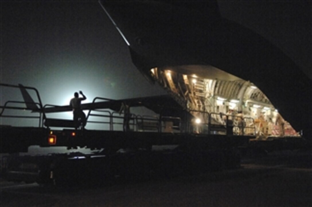 A U.S. Air Force airman assigned to the 332nd Expeditionary Logistics Readiness Squadron guides cargo being unloaded from a C-17 Globemaster III aircraft at Joint Base Balad, Iraq, on June 24, 2008.  