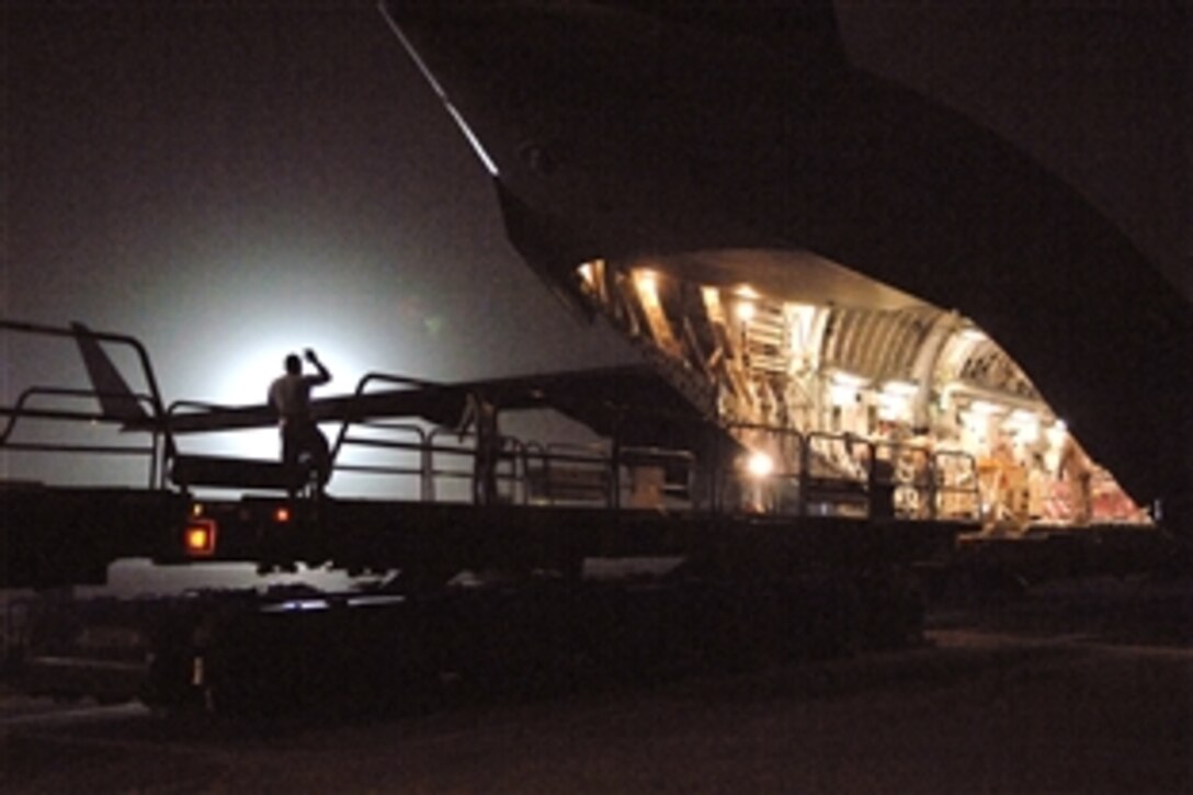 A U.S. Air Force airman guides cargo onto a loader from a C-17 Globemaster III at Joint Base Balad, Iraq, June 24, 2008. A quick downloading of all cargo and passengers allows the aircraft to spend the least amount of time on the ground. The airman is assigned to the 332nd Expeditionary Logistics Readiness Squadron.
