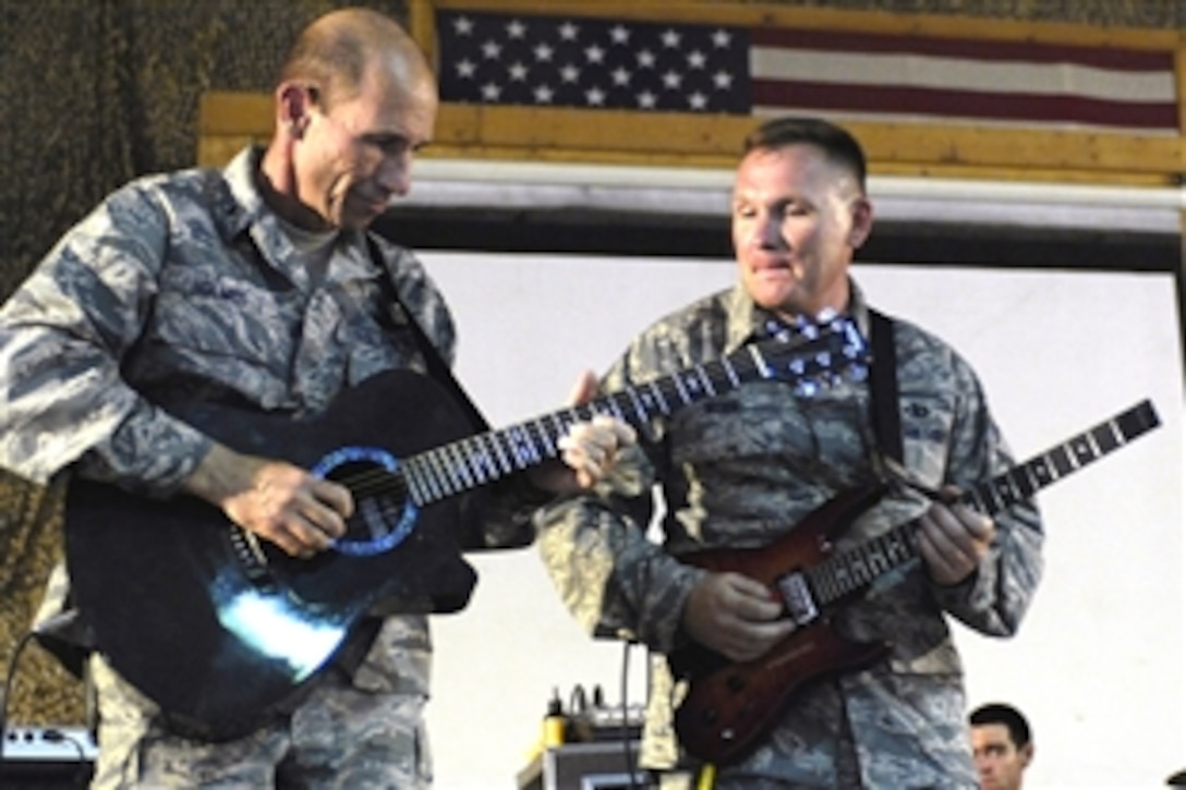 U.S. Air Force Brig. Gen. James "Mike" Holmes plays guitar alongside Senior Master Sgt. James Weber as part of the U.S. Air Force's Central Band "Falcon" during a concert at Bagram Air Base, Afghanistan, June 22, 2008. The band travels throughout the area of responsibility to promote troop morale and to reach out to host nation communities. Holmes is the 455th Air Expeditionary Wing commander. Weber is the band's vocalist and guitarist.