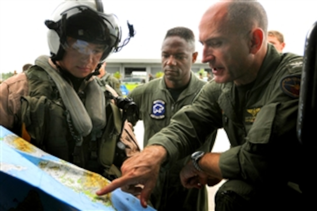 Capt. Thomas P. Lalor, right, gives Lt. Ralph Silvas, both U.S. sailors, directions to deliver humanitarian supplies on Panay Island, Roxas, Philippines, June 26, 2008. Lalor is coordinating air operations for the Ronald Reagan Carrier Strike Group while they assist the Republic of the Philippines in the wake of Typhoon Fengshen. 