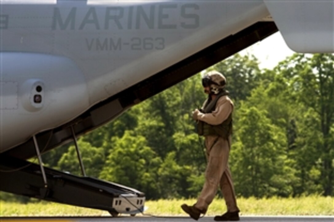 A U.S. Marine Corps crew chief inspects a V-22 Osprey and informs the pilots that the aircraft is ready for takeoff to conduct a routine flight training mission over Camp Atterbury, Ind., June 12, 2008. 