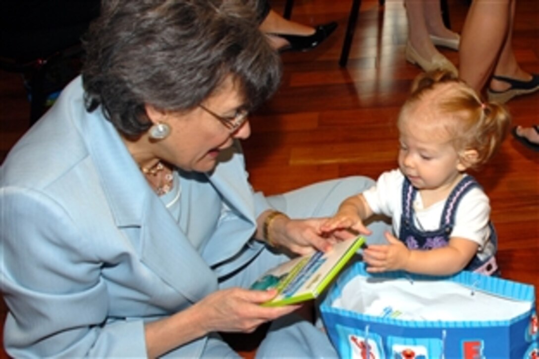 Jillian Kule shows Leslye Arsht, deputy under secretary of defense for Military Community and Family Policy, the new DVD she got June 26, 2008 at the Reserve Officer Association in Washington, D.C., during the launch of Sesame Workshop's "The Sesame Street Experience." Both the DVD and the live show were developed with the support of Arsht's office to help young military children cope with parents' deployments.  Thirteen-month-old Jillian is the daughter of Nancy and former Army Capt. Ryan Kule.