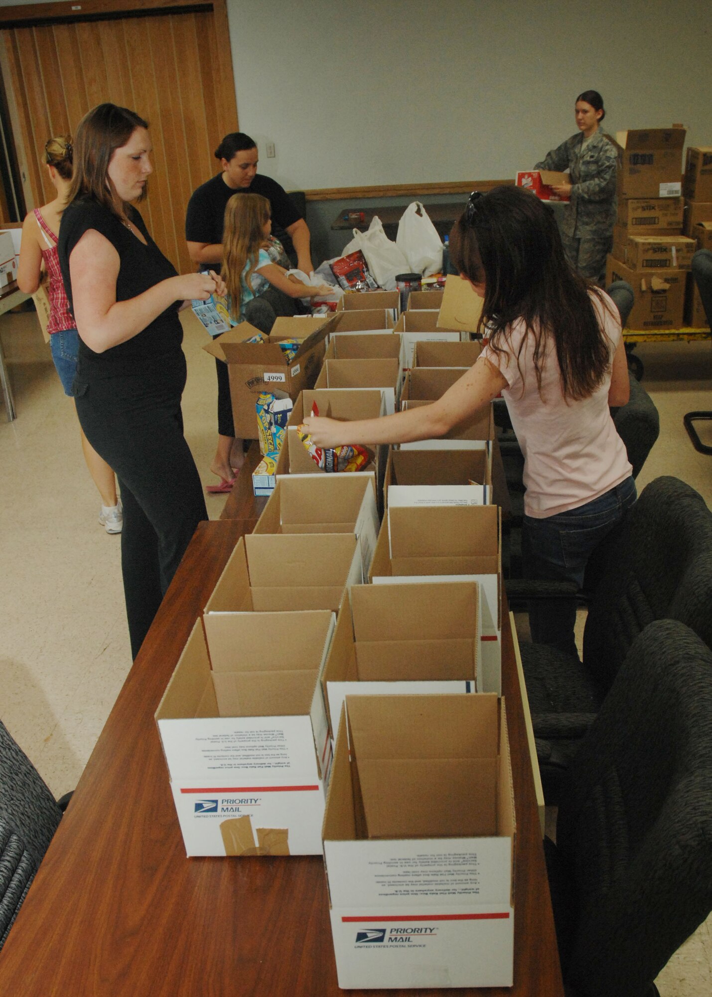 CANNON AIR FORCE, BASE, N.M. -- Spouses, families and military members distribute non-perishable items into care packages June 27. The packages will be sent to 27th Logisitic Readiness Squadron Airmen who are deployed. (U.S. Air Force photo by Airman 1st Class Evelyn Chavez)