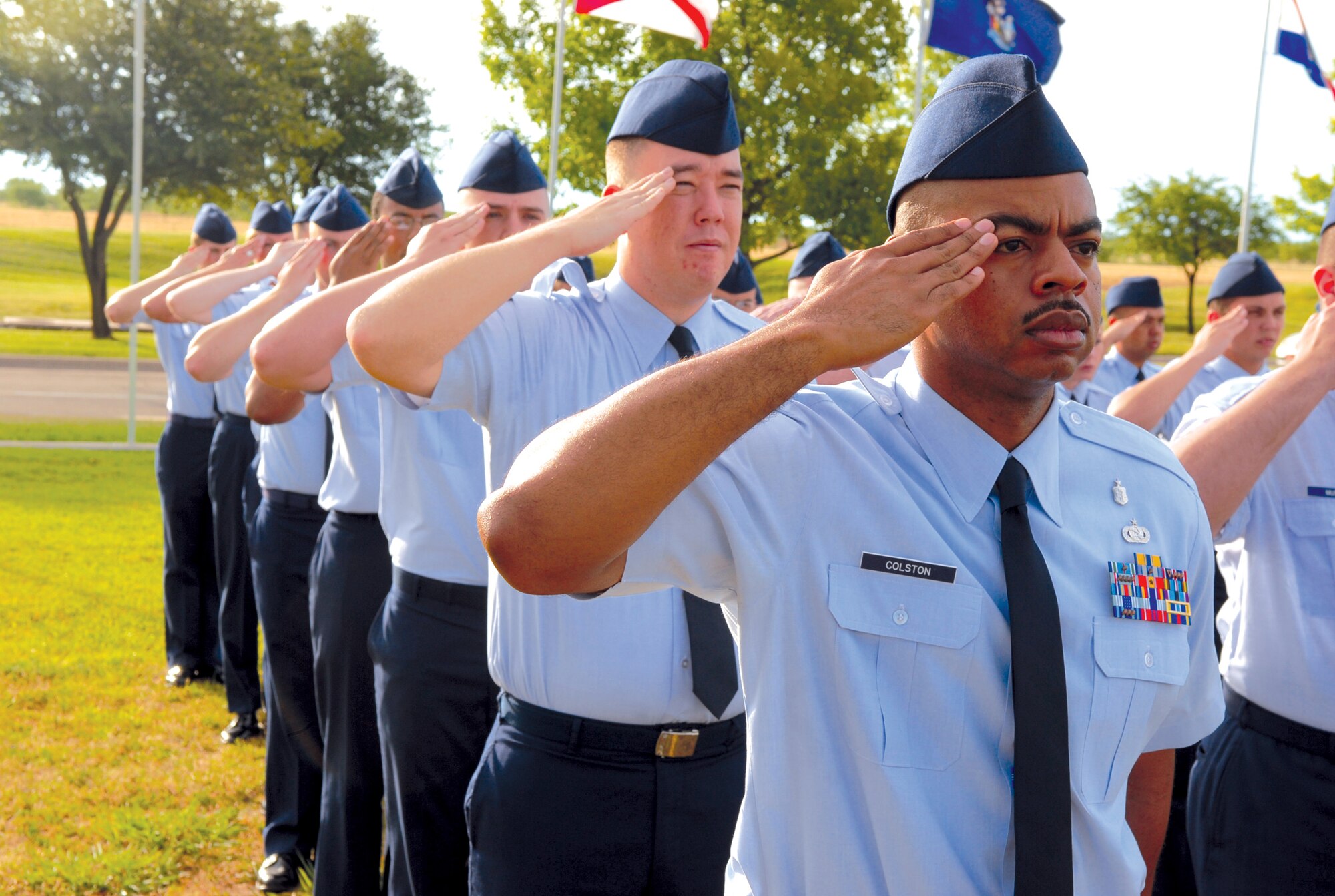 Tech. Sgt. Charles Colston, the A-flight guide for the 17th?Medical Group and 17th Training Wing staff, renders a salute to the flag as the Star-Spangled Banner is sung by Airman 1st Class Jennifer Bone during the Pass in Review June 20. (U.S. Air Force photo by Staff Sgt. John Barton)