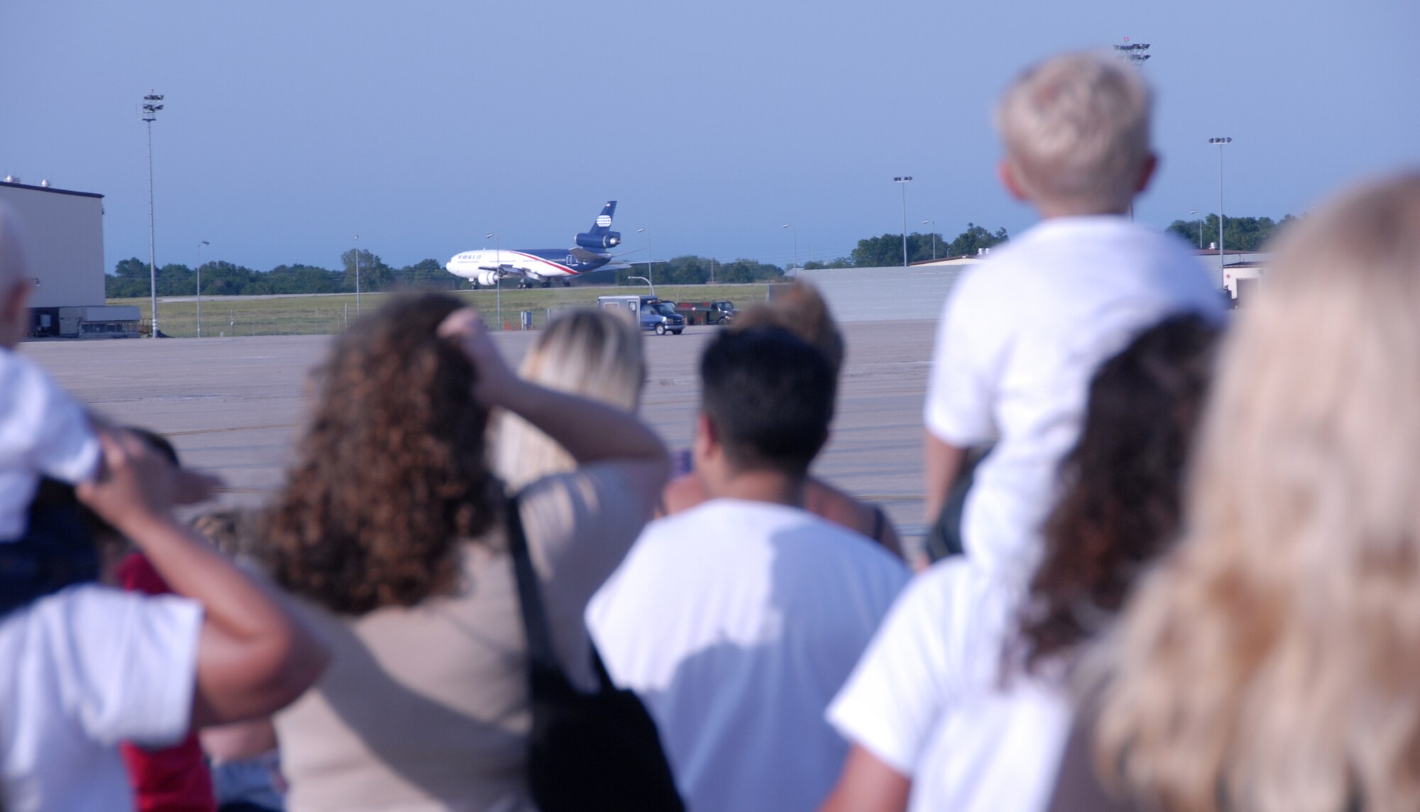 Family members watch expectently as a contracted DC-10 rolls to a stop on the Whiteman Air Force Base, Mo., runway June 26, 2008.  On board are approximately 250 Air Force Reservists from the 442nd Fighter Wing returning from a 51-day deployment to Bagram Air Base, Afghanistan.  The Citizen Airmen supported Operation Enduring Freedom by flying and maintaining A-10 Thunderbolt II aircraft on combat missions against anti-Afghan insurgents.  (U.S. Air Force photo/Master Sgt. Bill Huntington) 