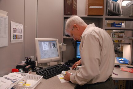 Pharmacy employees such as Paul Shonebarger rely on their computers to dispense medications. (U.S. Air Force photo by Rich McFadden)
