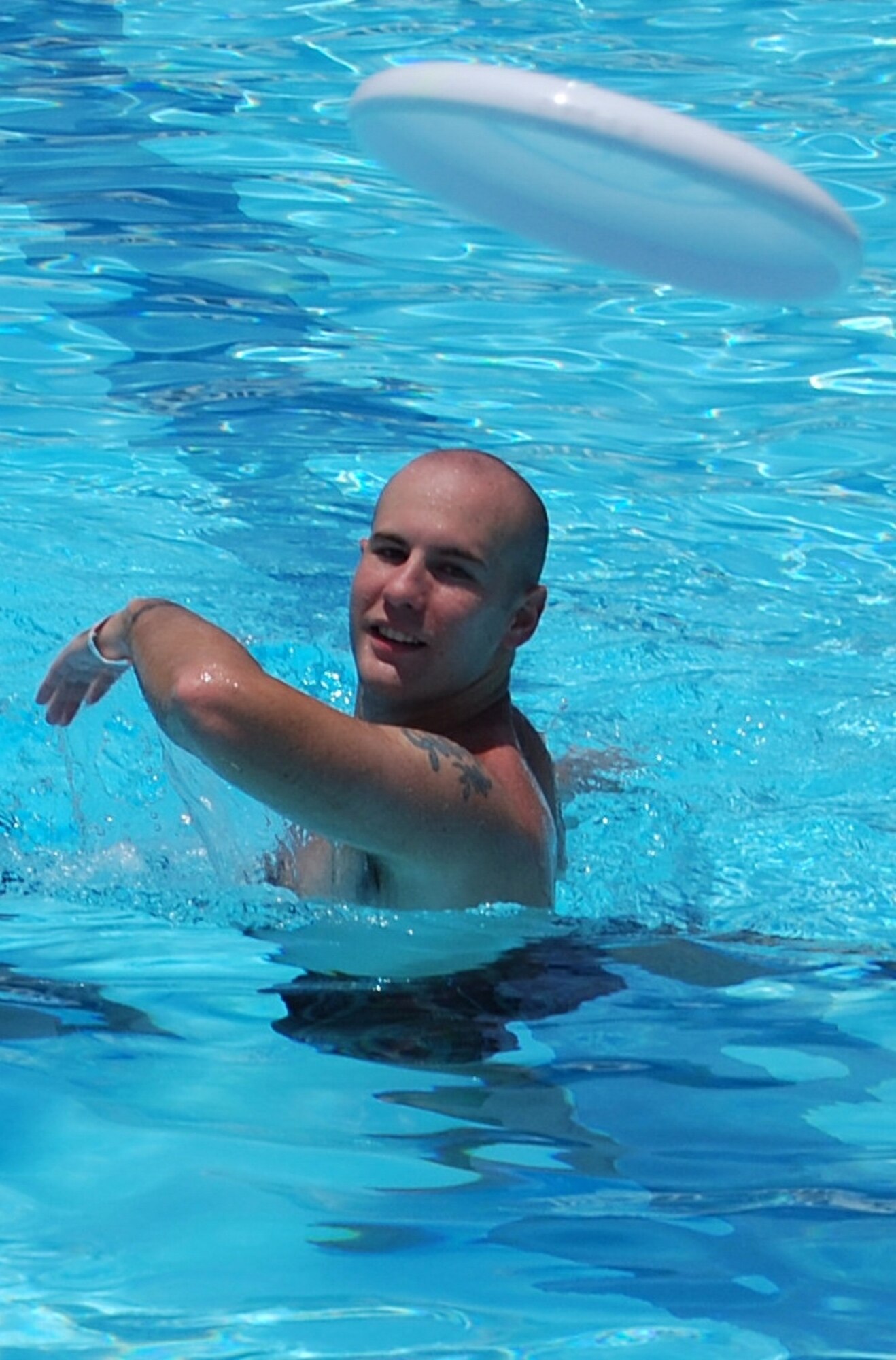 Comin' at you! Airman 1st Class Dustin Brundrett lobs a frisbee during the Junior Enlisted Picnic held at the Tides.