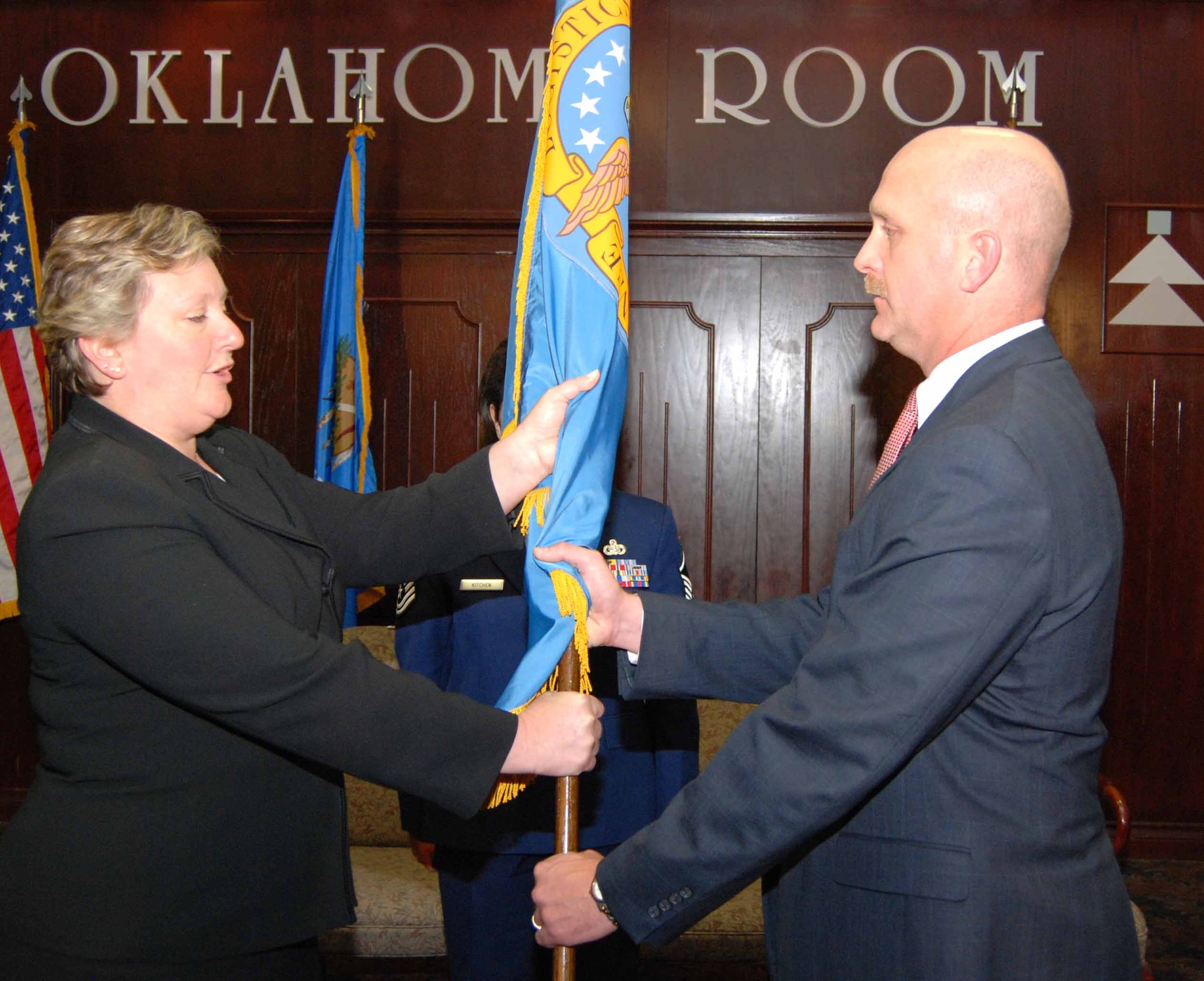 Yvette Burke, DSCR's acquisition executive, passes the Defense Logistics Agency flag to Michael Yort, chief contracting officer for depot-level reparable items during a June 18 activation ceremony in the Bldg. 3001 Oklahoma Room.  (Photo by Debra Bingham)