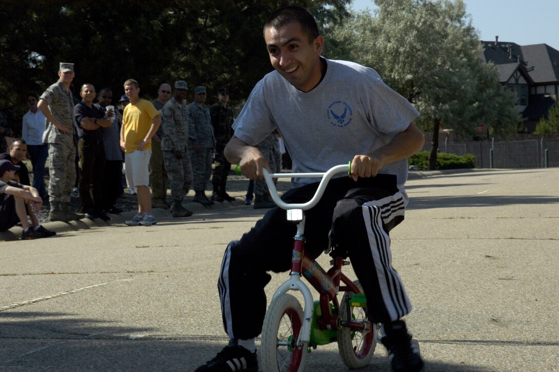 Airman 1st Class Miguel Magana, DPS, takes a tricycle for a ride during the ARPC obstacle course June 27. The event raised $140 toward the ARPC summer picnic. The winning team was the DPB team of: Staff Sgts. Damien Pierce, Jason Burbach and Ramon Montoya, and Senior Airman Jason Mendoza. (U.S. Air Force photo/Mike Molina)                                