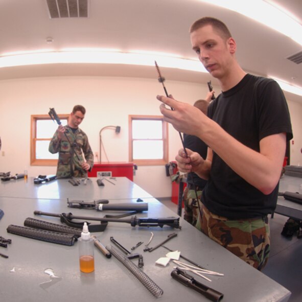 MINOT AIR FORCE BASE, N.D. -- Airman 1st Class Gregory Gilmer, 5th Comptroller Squadron, cleans an M-16 rifle during augmentee training here June 25. Augmentees are volunteer Airmen from a wide variety of Air Force career fields who assist the 5th Security Forces Squadron by performing base security duties; enabling regular SFS personnel to perform other roles in support of air base defense. Augmentees are given specialty training in weapons, possible scenarios, rules of engagement and use of force. (U.S. Air Force photo by Airman 1st Class Sharida Bishop)