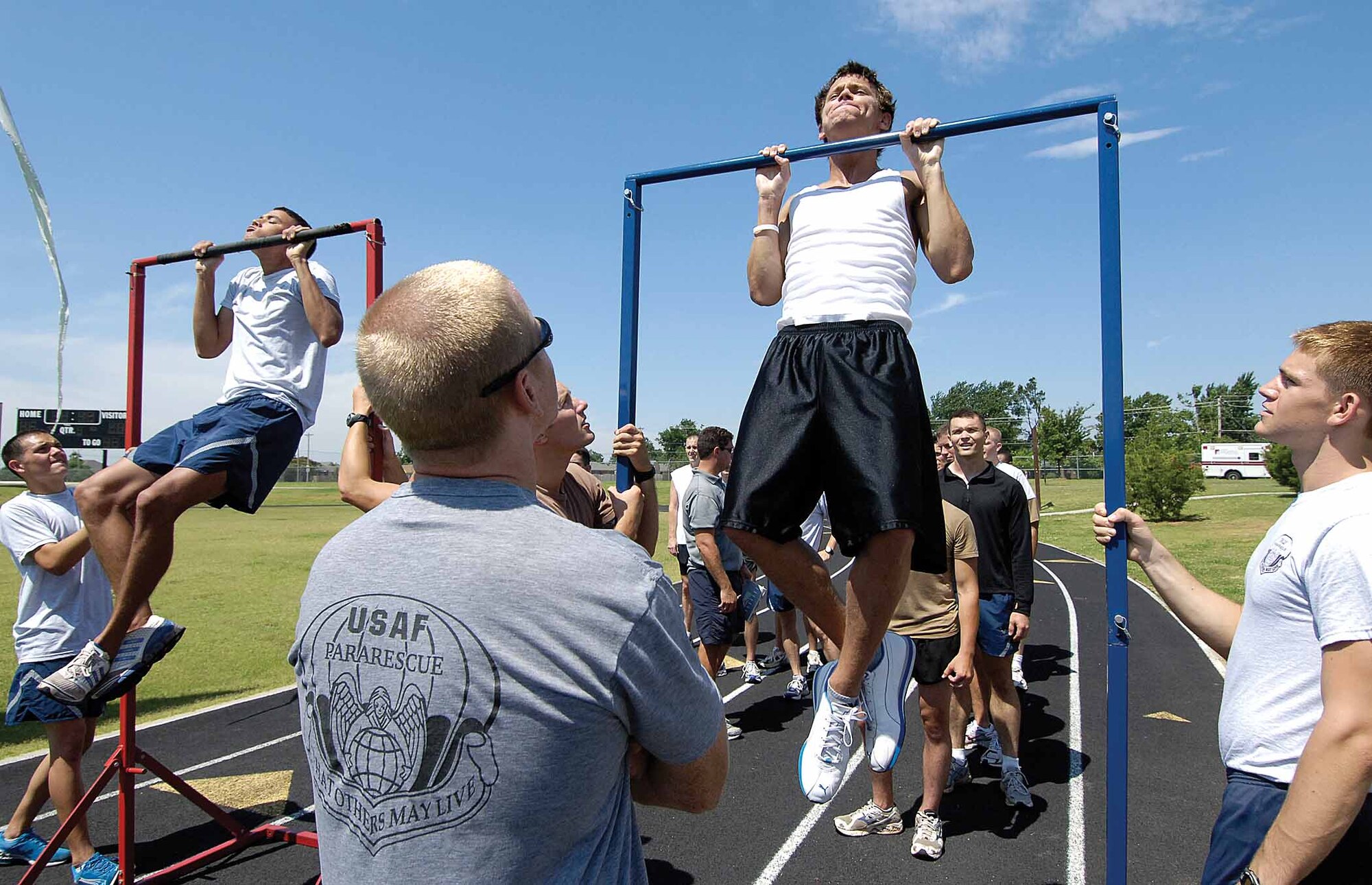 William Martens, right, forces another pull up in the timed stamina test, one of  back-to-back stamina tests he and other pararescue and combat control hopefuls took June 19 at Tinker.  Mr. Martens isn’t an Airmen yet, but left two years of college behind for the delayed enlistment program and dreams of being a pararescue Airman.  “It’s the only thing that’s going to fulfill my life”, he admitted between tests.  His recruiter vouched for the man’s passion for the Air Force career, saying he trains six days a week .  His efforts paid off this day; he had the highest scores, earning 324 out of 330 possible points.  (Air Force photo by Margo Wright)