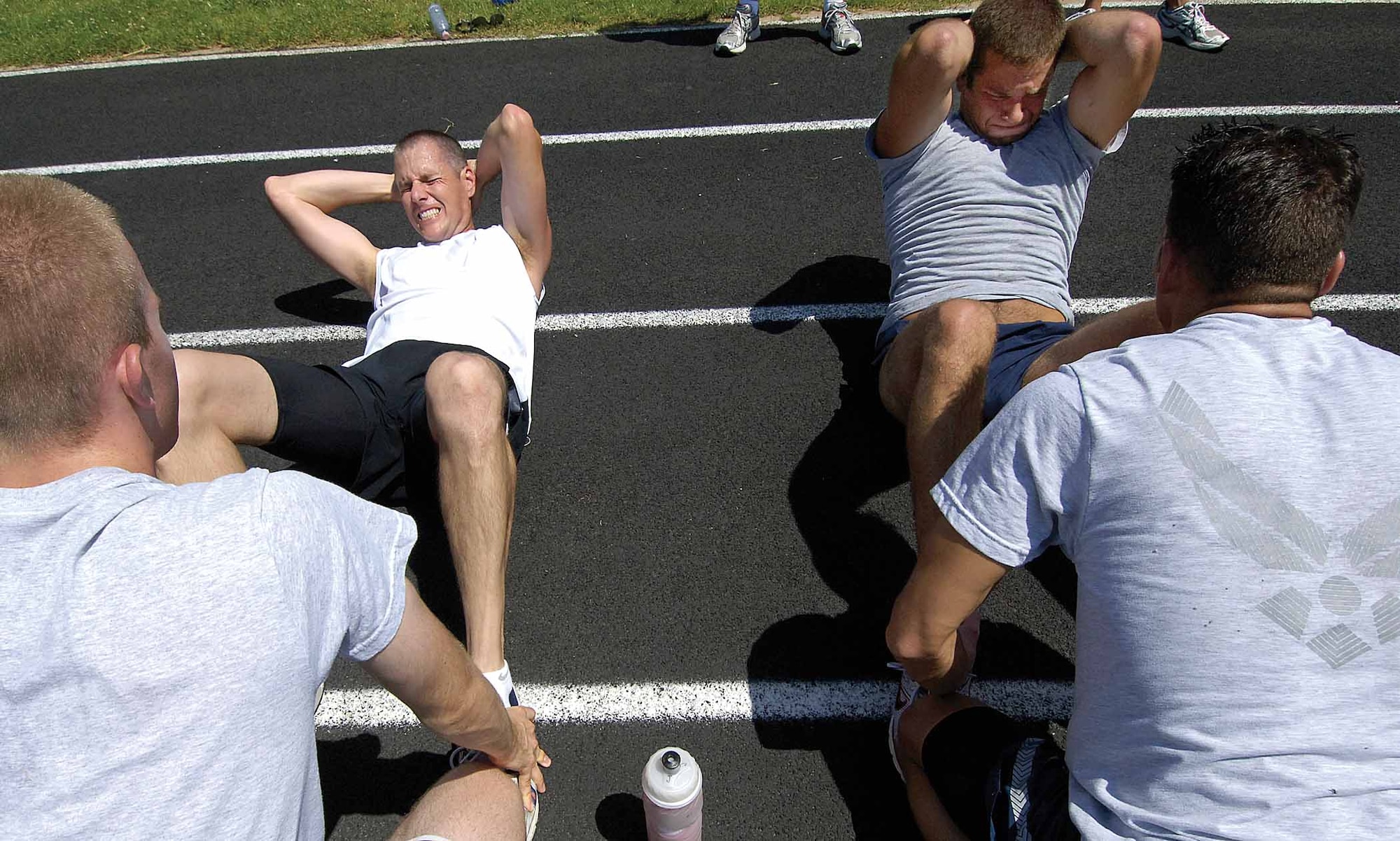 Daniel Pirrie, left, and Senior Airman Zachary Hesse, 552nd Aircraft Maintenance Squadron, strain for one more sit-up before time is called.  Mr. Pirrie was one of the civilian participants for the pararescue/combat control recruiting test.  An inactive reservist, he wants to return, serving as a “PJ”.  (Air Force photo by Margo Wright)
