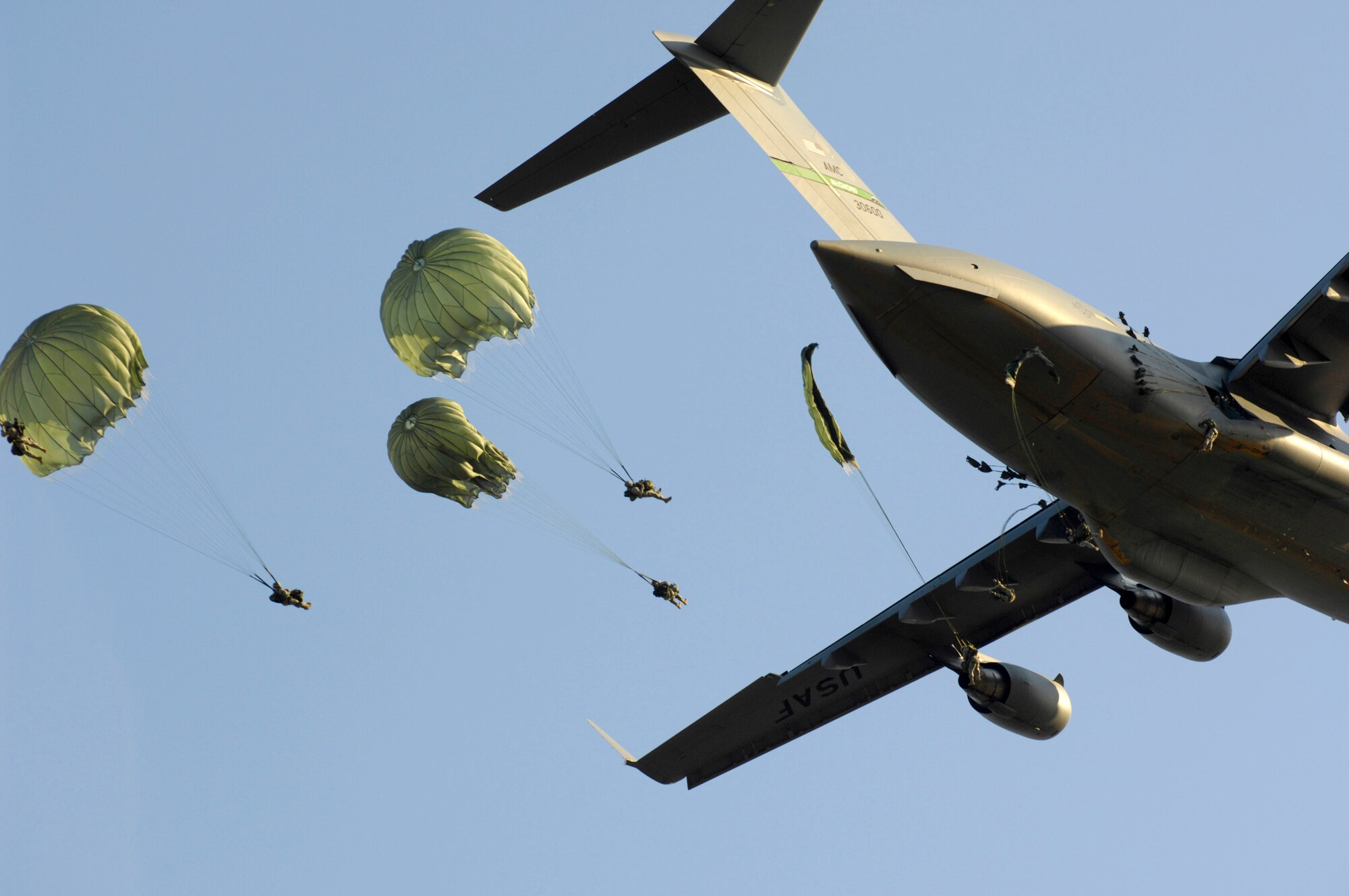 Paratroopers from the 82nd Airborne Division jump from a C-17 Globemaster III during Joint Forcible Entry Exercise June 18 at Fort Bragg, N.C. The exercise is a joint airdrop exercise designed to enhance service cohesiveness between Army and Air Force members, allowing both services an opportunity to properly execute large-scale heavy equipment and troop movement. (U.S. Air Force photo/Staff Sgt. Jacob N. Bailey)