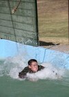 6/11/2008 - Air Force Academy Cadet 2nd Class Cohan Lammerding didn't quite make it through a water obstacle at the basic military training obstacle course.  Cadet Lammerding is going through Lackland's Summer Leadership Program to observe how military training instructors turn a flight of approximately 50 trainees into a team.
(USAF photo by Robbin Cresswell)