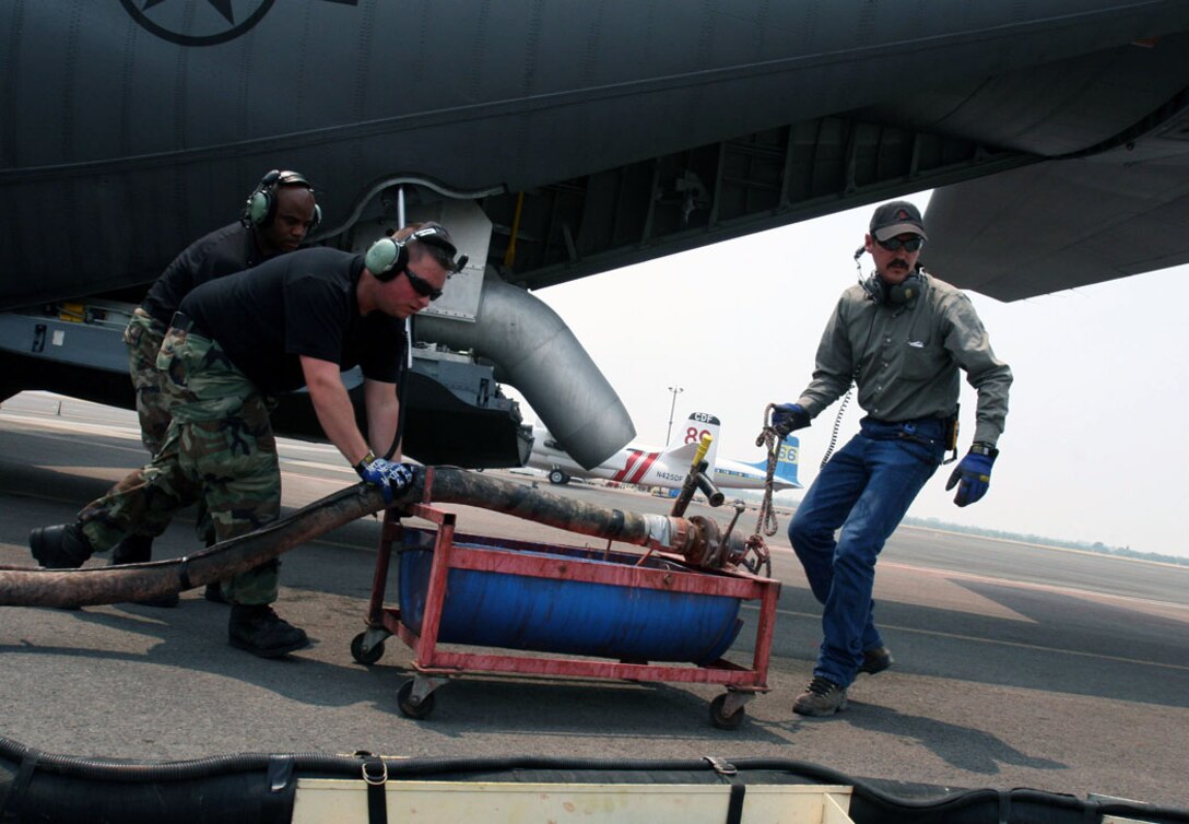 Airmen and civilians from the 302nd Air Expeditionary Group hastily move fire retardant ‘slurry’ June 26 after loading the red powder onto a C-130 June 26 at Chico Municipal Airport in California. The group received its first execution order to launch fire suppression missions since first arriving June 23. The Airmen have waited up to three days for smoke to clear enough over the wildfire to allow for modular airborne firefighting system fire suppression drops. The group is made up of three Air National Guard units, including the 153rd AW, from Cheyenne, Wyom.; the 146th AW, from Channel Islands, Calif.; and the 145th AW, Charlotte, N.C. One Air Force Reserve unit, the 302nd AW from Peterson Air Force Base, Colo., is the only Air Force Reserve unit in the 302nd AEG. (U.S. Air Force photo/Master Sgt. Heldwin Brito)
