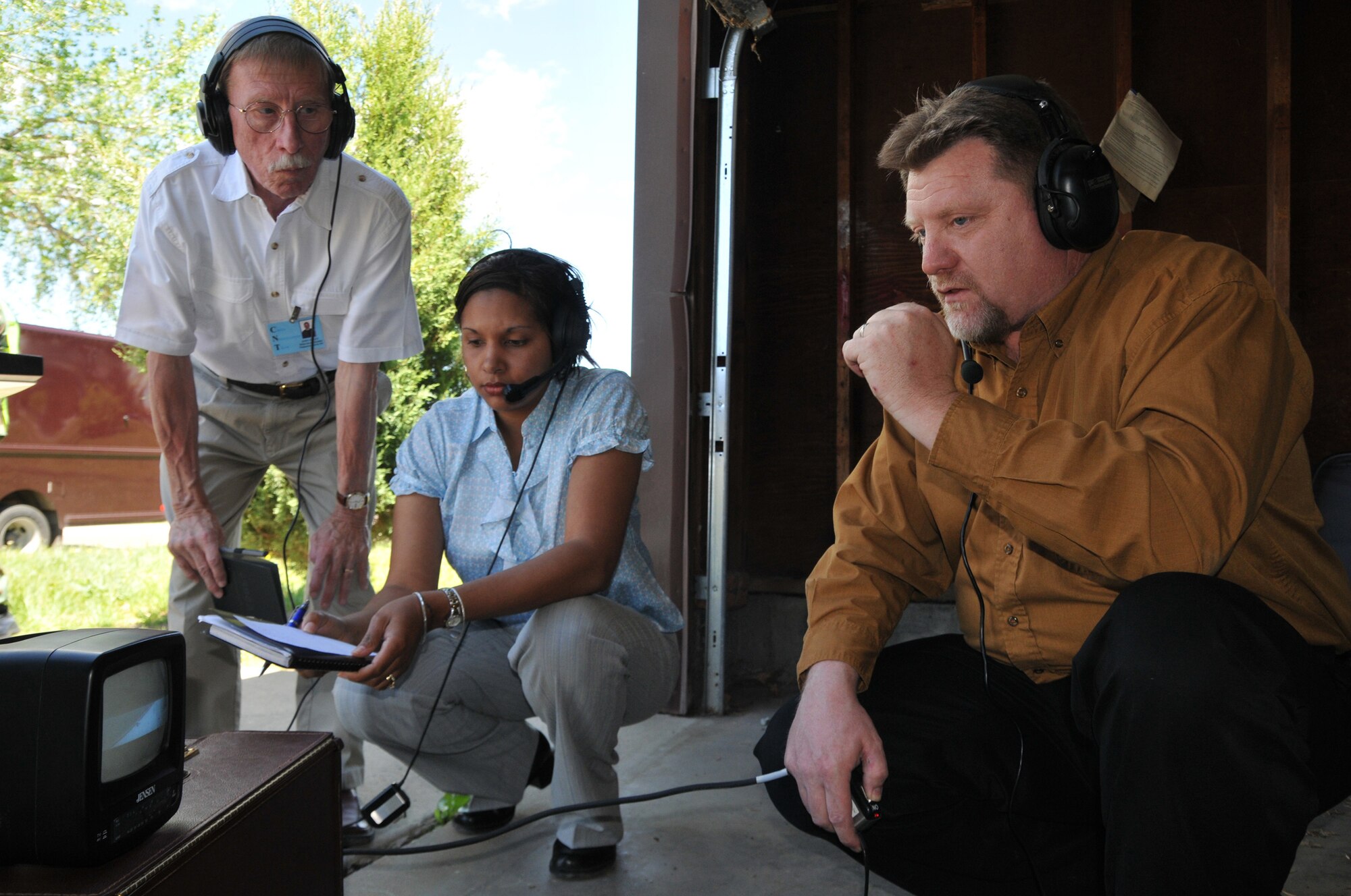John Foley, Airman and Family Readiness director, Karan Killiard and David Burger, cmmunity readiness consultants, conduct negotiations with a hostage taker during an exercise June 23. The exercise was held in base housing to simulate response to a hostage situaiton. (U.S. Air Force photo/John Turner)