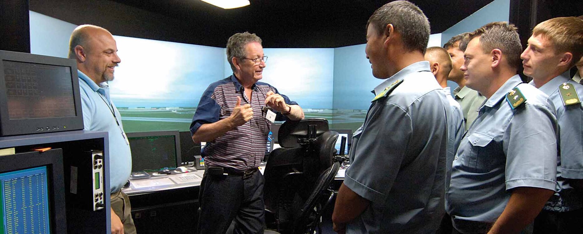 Military members from Kazakhstan, Tajikistan and Kyrgyzstan listen to U. S. State Department interpreter Alan French give the Russian translation about Tinker’s air traffic control tower simulator during a June 17 tour.  Tinker’s tower simulator administrator Dave Melton, left, guided the tower tour. (Air Force photo by Margo Wright)
