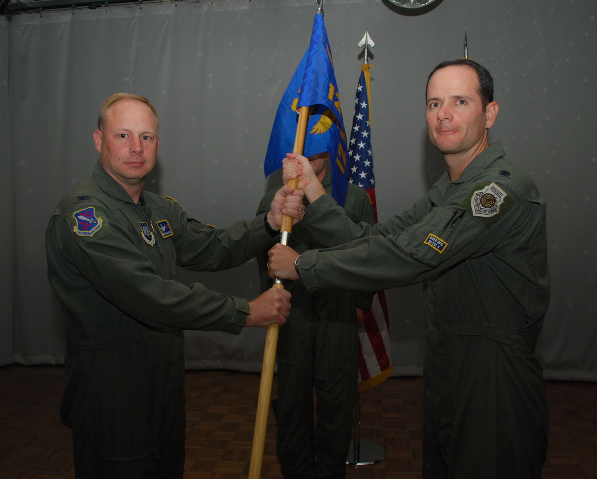 THULE AIR BASE, Greenland – Lt. Col. David Meteyer receives the 12th Space Warning Squadron guidon from Col. Chris Crawford, 21st Operations Group commander, as he assumes command during the squadron’s change-of-command ceremony June 26 at the Top of the World Club here. The 12th SWS provides critical, real-time warning of ballistic missile attacks against North America and detects, tracks and identifies earth-orbiting objects in support of U.S. Strategic Command's space control mission. (U.S. Air Force photo/1st Lt. Nicole Langley)

