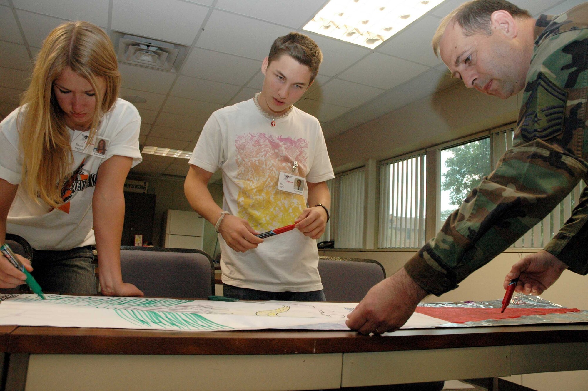 Senior Master Sgt. Brendt traicorr, 934th Airlift Wing senior recruiter, assists Megan Beard and John Iten with a balloon building project as part of the Aviation Career Education camp here June 23-27. The camp is hosted by the 934th Airlift Wing and gives aviation career-minded high school juniors and seniors first-hand exposure to aviation careers including small aircraft flights, tower tours and ground school.  Air Force Photo/Master Sgt. Paul Zadach