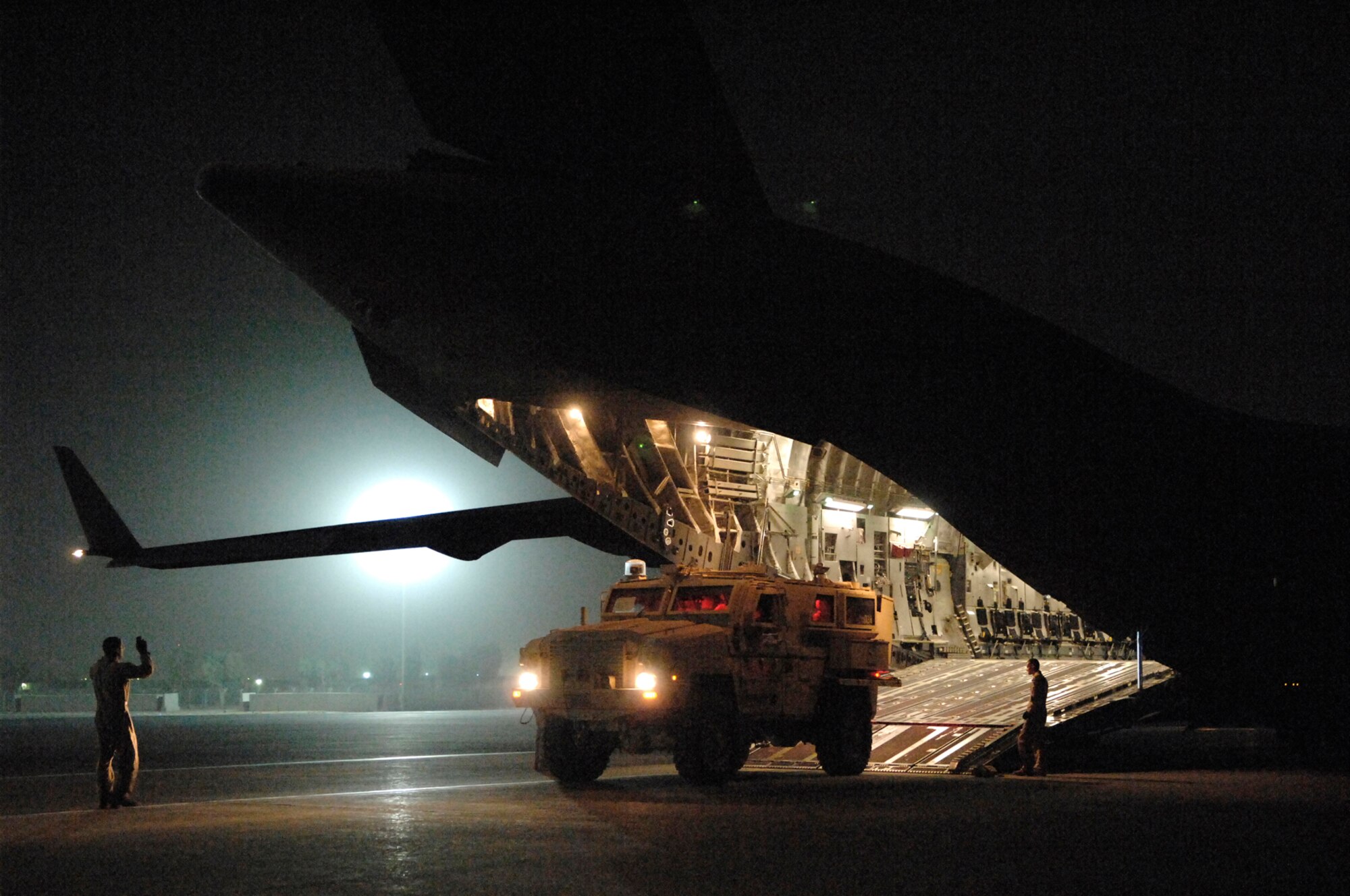 JOINT BASE BALAD, Iraq -- A loadmaster ushers in a Mine Resistant Ambush Protected armored vehicle into a C-17 Globemaster III here, June 24. The distribution of the MRAP vehicle is critical to the survival of servicemembers operating in a combat environment where they may face improvised explosive device attacks. (U.S. Air Force photo/ Senior Airman Julianne Showalter)