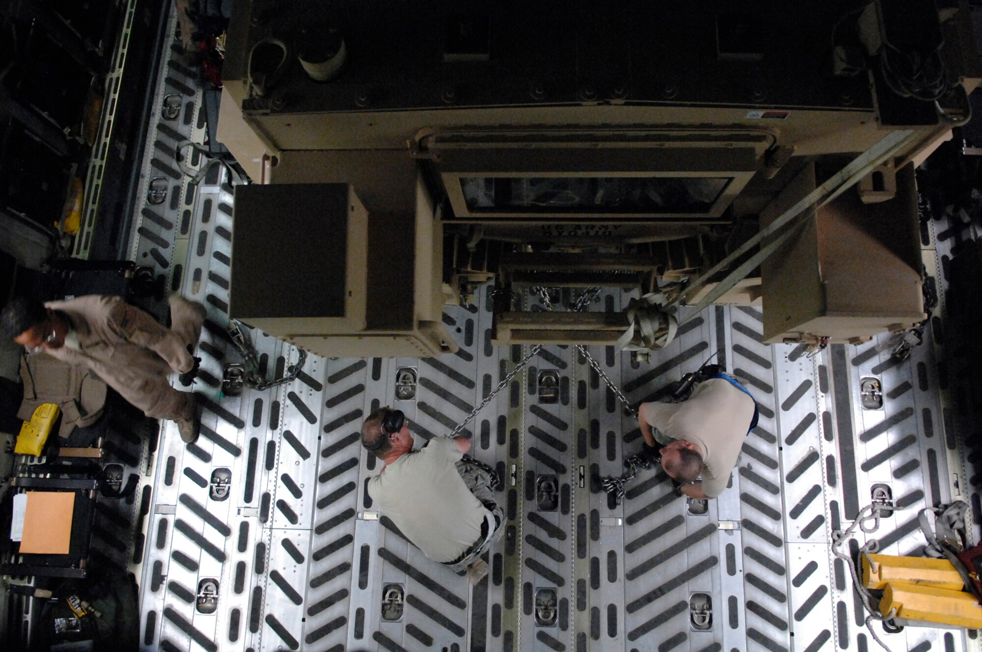 JOINT BASE BALAD, Iraq -- Master Sgt. Bill Hobbs and Staff Sgt. Jason Orendorff, 332nd Expeditionary Logistics Readiness Squadron aerial porters, secure a Mine Resistant Ambush Protected armored vehicle into a C-17 Globemaster III here, June 24. Ensuring the MRAP vehicle is properly secured with chains is critical to the safety of the crew, equipment and passengers aboard. Sergeant Hobbs and Sergeant Orendorff are both deployed from Travis Air Force Base, Calif. (U.S. Air Force photo/ Senior Airman Julianne Showalter)