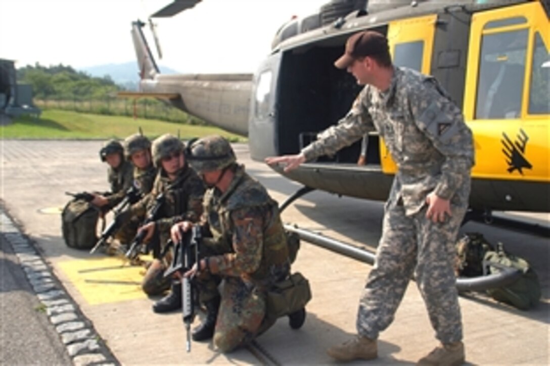 U.S. Army Staff Sgt. David Miller conducts pre-flight safety instruction with a group of German soldiers during U.S.-German Army Partnership Air Assault training at the Joint Multinational Readiness Center in Hohenfels, Germany, June 25, 2008. Miller is assigned to Hohenfels as a Aviation Detachment "Falcon Team" Observer/Controller.