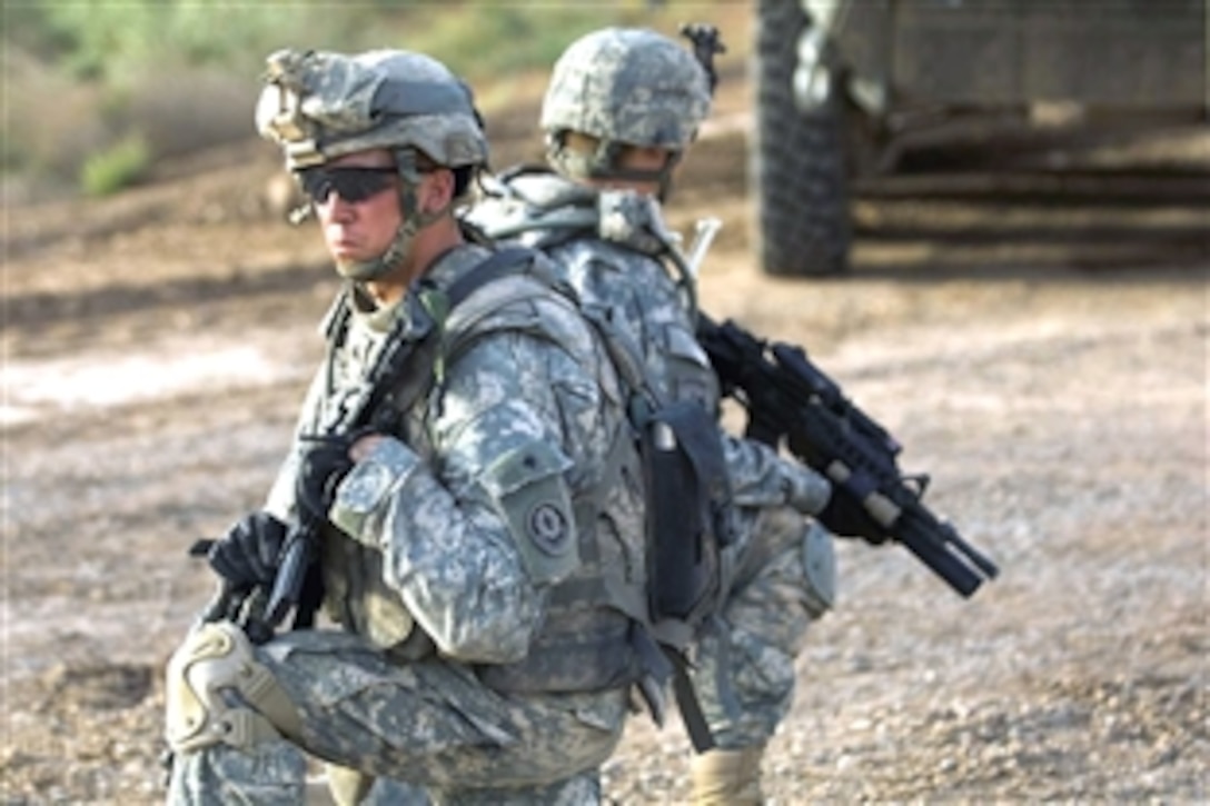Two U.S. soldiers provide rear security for a patrol in support of Operation Cougar Storm in Mullaid and Naquib, Iraq, June 23, 2008. Cougar Storm was implemented to protect the population and reestablish Iraqi government and security forces in the area. The soldiers are assigned to 2nd Squadron, 2nd Stryker Cavalry Regiment. 