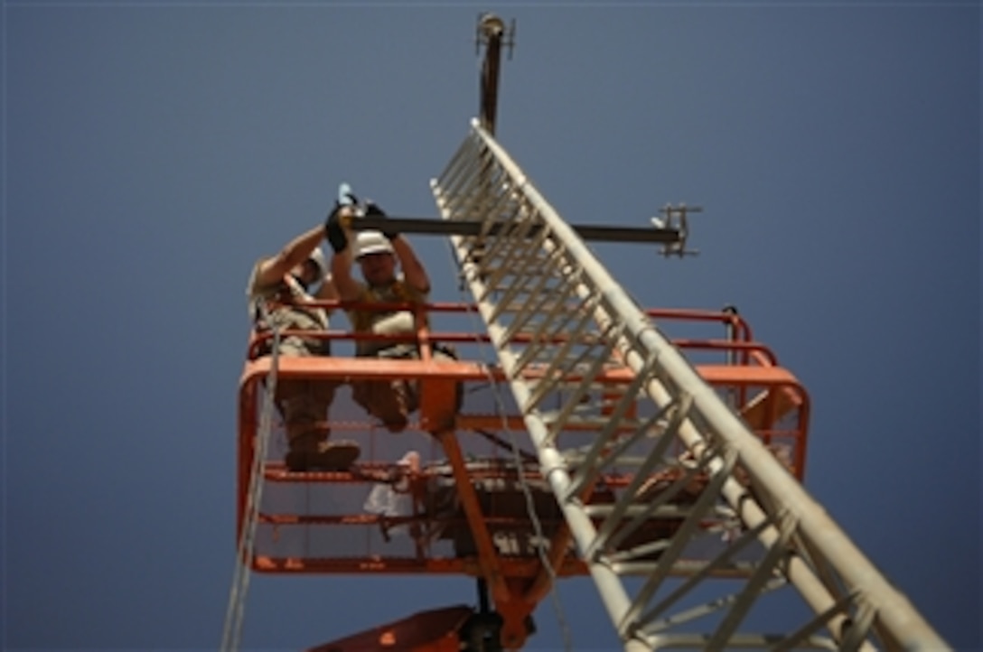 Two U.S. Air Force ground radio maintainers assigned to the 332nd Expeditionary Communications Squadron secure a high-frequency radio antenna to a communications tower on Joint Base Balad, Iraq, on June 21, 2008.  Tactical and land mobile radio support is critical to ground-to-air communications for combat air power.  