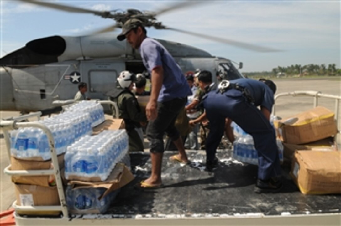 Bottles of water are unloaded from an SH-60F Seahawk helicopter by Armed Forces of the Philippines service members, civilians and U.S. Navy sailors from the Nimitz-class aircraft carrier USS Ronald Reagan (CVN 76) in the Philippines on June 26, 2008.  The Ronald Reagan Carrier Strike Group is providing humanitarian assistance and disaster relief to victims of Typhoon Fengshen, which struck the Philippines on June 23, 2008.  