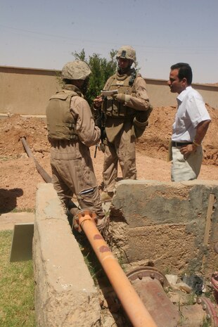 2nd Lt. Dan J. Alldridge, Officer in Charge with Detachment 1, Civil Affairs Team 4, 2nd Battalion, 11th Marine Regiment, Regimental Combat Team 5, talks with the manager of the water treatment facility with through an interpreter in Rutbah, Iraq, June 27. Marines with CA Team 4 inspected the facility to see about putting in a generator that would free the pump house from being dependant on the national power grid. Currently, the city of Rutbah only has power for usually six to eight hours a day.::r::::n::