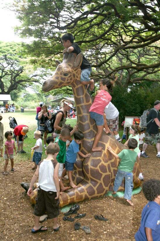 Dozens of children play on a fake giraffe June 28 at the Honolulu Zoo during Military Appreciation Day, sponsored by the United Services Organization, the zoo and the city and county of Honolulu.