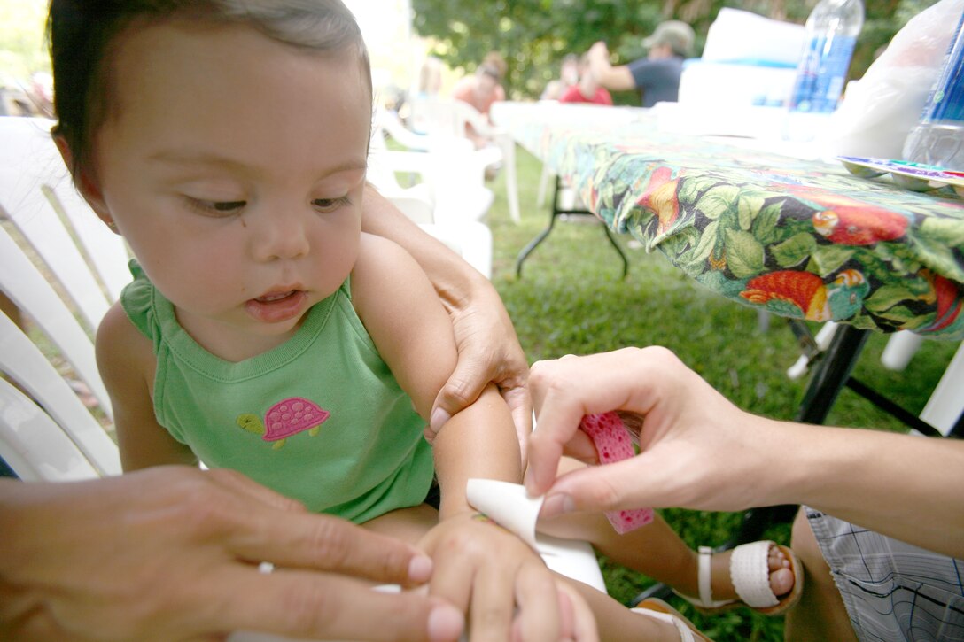 Kai Carro Smiles as an artist peels a butterfly sticker tattoo off her hand June 28 at the Honolulu Zoo during Military Appreciation Day. The event featured numerous face painting and coloring stations for children to enjoy. Carro is an 18-month-old Navy Dependant.