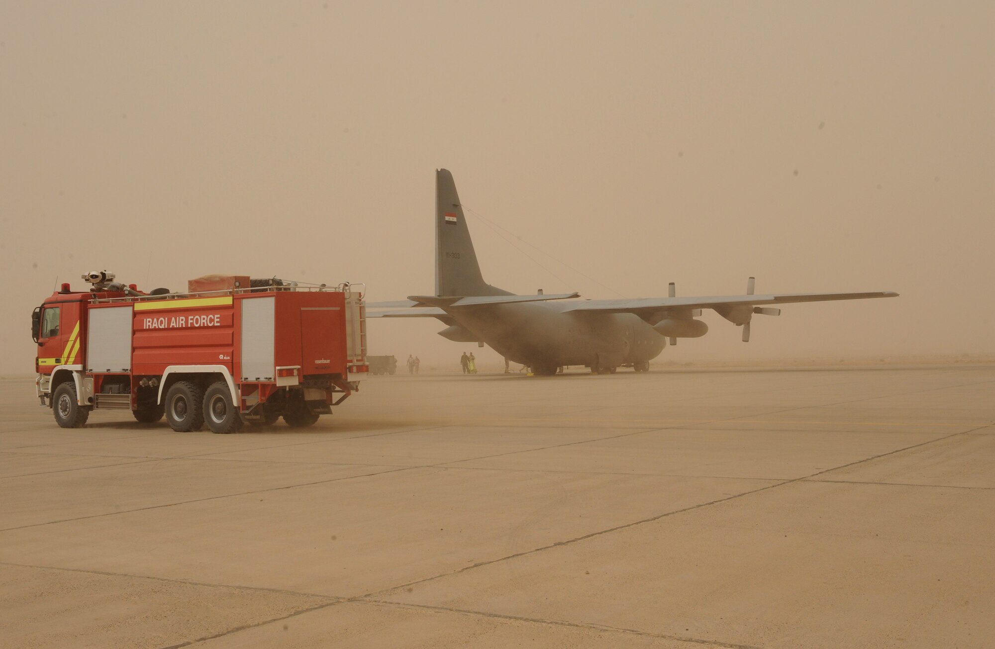 SATHER AIR BASE, Iraq -- Iraqi firemen respond to a simulated fire on an Iraqi C-130 at New Al Muthana Air Base, Iraq. The simulation was part of a ground emergency exercise to test the Iraqi's notification and response. (U.S. Air Force photo/Tech. Sgt. Amanda Callahan)