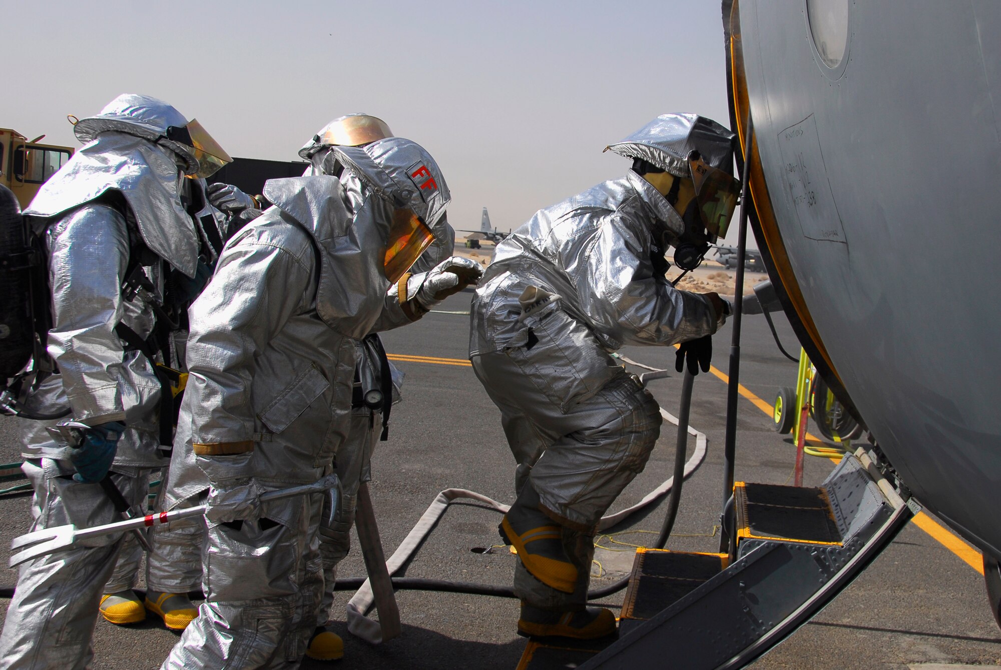 SOUTHWEST ASIA -- Firefighters deployed to the 386th Expeditionary Civil Engineer Squadron, enter a disabled C-130 Hercules to shutoff oxygen, put out fires, ventilate, and search and rescue for victims once inside the cargo area of the disabled aircraft June 26, 2008, during a major accident response exercise at an air base in the Persian Gulf Region. The purpose of the MARE is to evaluate the Wing's ability to respond to and recover from an aircraft mishap and mass casualty incident. (U.S. Air Force photo/ Staff Sgt. Patrick Dixon)