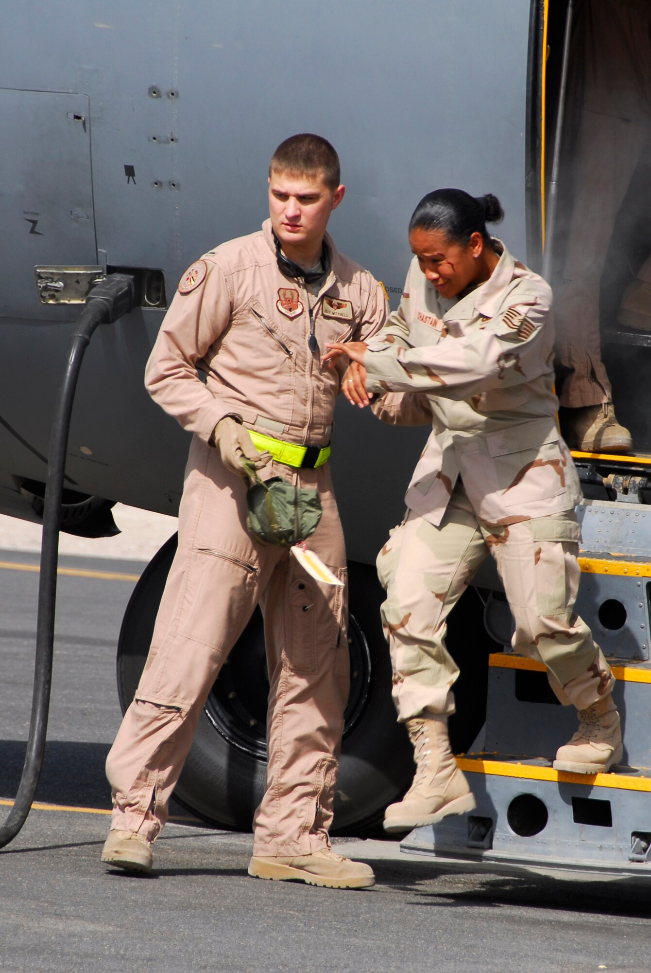 SOUTHWEST ASIA -- First Lt. Jeffrey Mitchell, a C-130 Hercules aircraft navigator deployed to the 737th Expeditionary Airlift Squadron, helps an injured passenger from the disabled aircraft June 26, 2008, during a major accident response exercise at an air base in the Persian Gulf Region. As part of the C-130 crew responsibilities, the crew makes sure that all of their passengers are directed off of the aircraft and away from any further dangers. The purpose of the MARE is to evaluate the Wing's ability to respond to and recover from an aircraft mishap and mass casualty incident. (U.S. Air Force photo/ Staff Sgt. Patrick Dixon)
