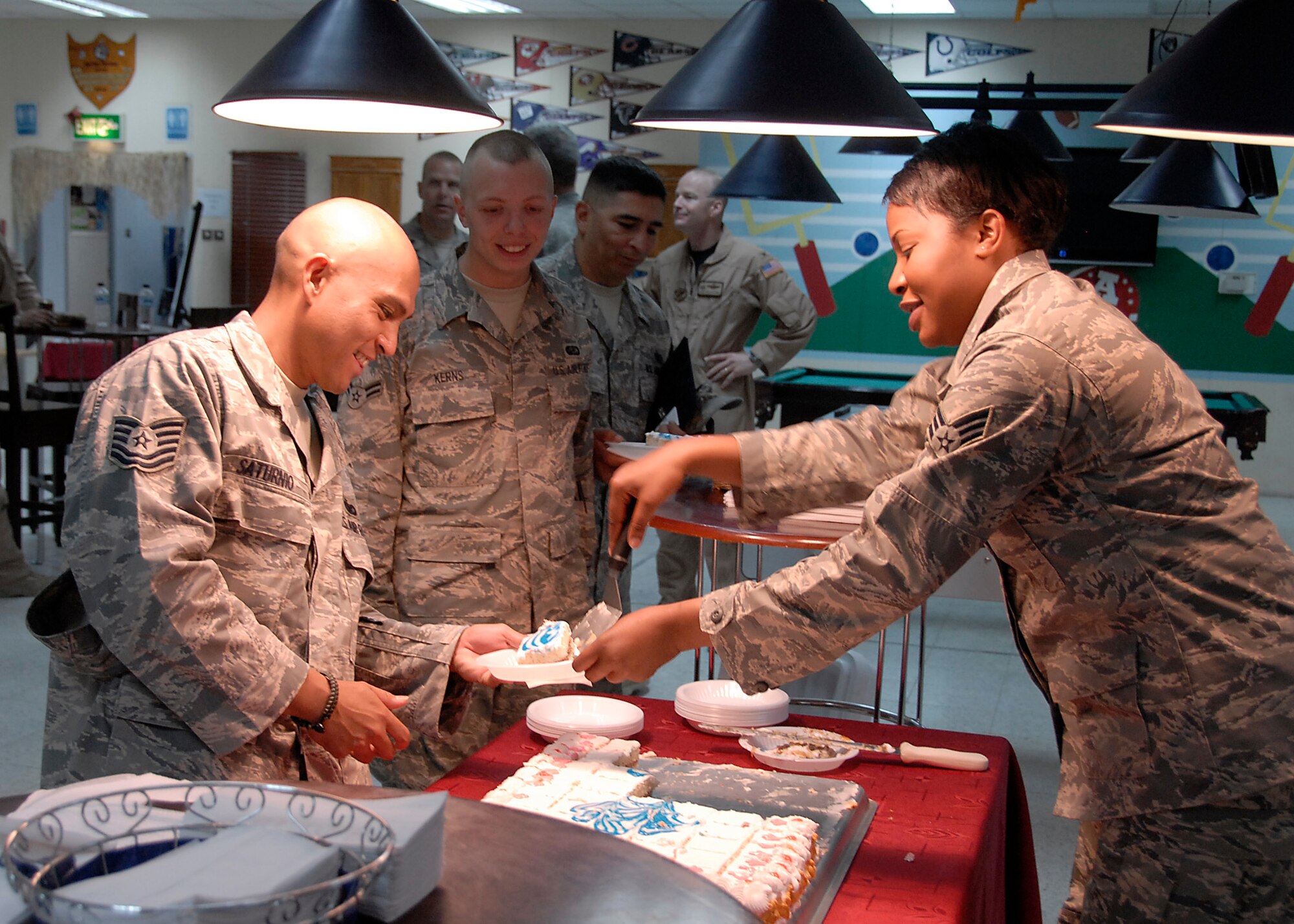 SOUTHWEST ASIA -- Senior Airman Nicole Nnoko, 386th Expeditionary Force Support Squadron serves cake to some of the Air Force's newest master and technical sergeants recently selected for promotion and their fellow Airmen who attended their promotion ceremony here June 27. (U.S. Air Force photo/Staff Sgt. Patrick Dixon)